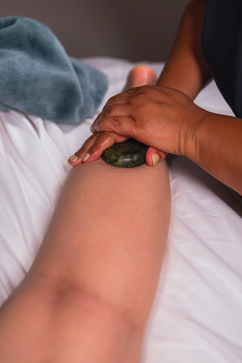 A warm basalt stone worked along a client&rsquo;s arm during a hot stone massage in Manotick